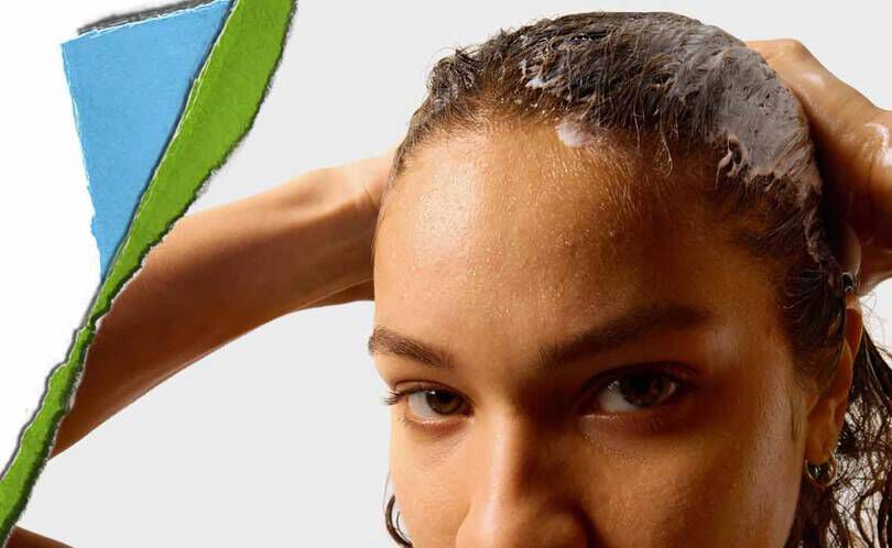 Een persoon met nat haar brengt een haarproduct aan, met een kleurrijk gescheurd stuk papier op de achtergrond.