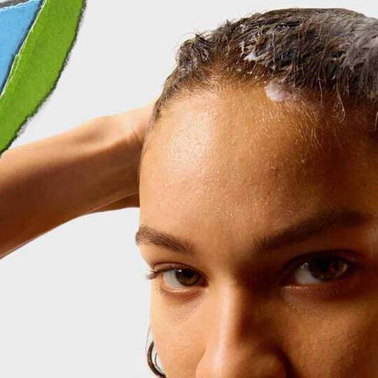 Een persoon met nat haar brengt een haarproduct aan, met een kleurrijk gescheurd stuk papier op de achtergrond.