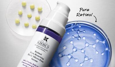 A close-up of Kiehl's Retinol Skin-Renewing Daily Micro-Dose Serum bottle next to a petri dish showcasing round capsules and molecular structures, emphasizing the product's pure retinol content.