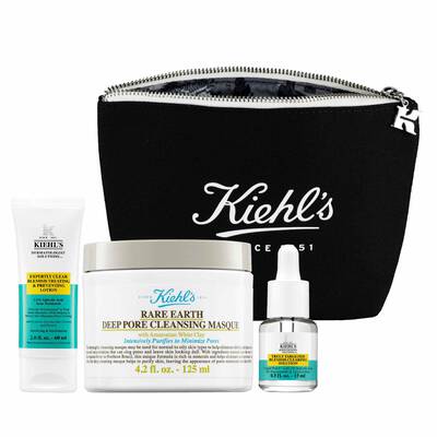 A black Kiehl's cosmetic bag containing three skincare products: a tube of cleanser, a jar of deep pore cleansing masque, and a dropper bottle of serum.