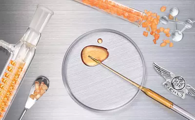 An assortment of laboratory tools and substances, including a glass vial with orange crystals, a petri dish with a drop of golden liquid, and a small spoon, arranged on a silver background, with a Kiehl's emblem.
