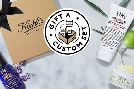 Alt-tekst: Een gift set van Kiehl's met verzorgingsproducten, waaronder een creme en serum, naast een cadeauverpakking en het Kiehl's-logo.