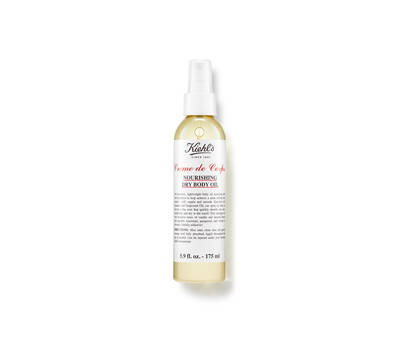 A spray bottle of Kiehl's Creme de Corps nourishing dry body oil, showcasing a sleek design with a white label and red text.