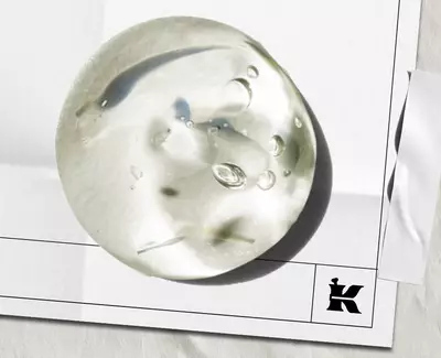 A wooden spoon holds several translucent, cube-shaped jelly candies against a white background.
