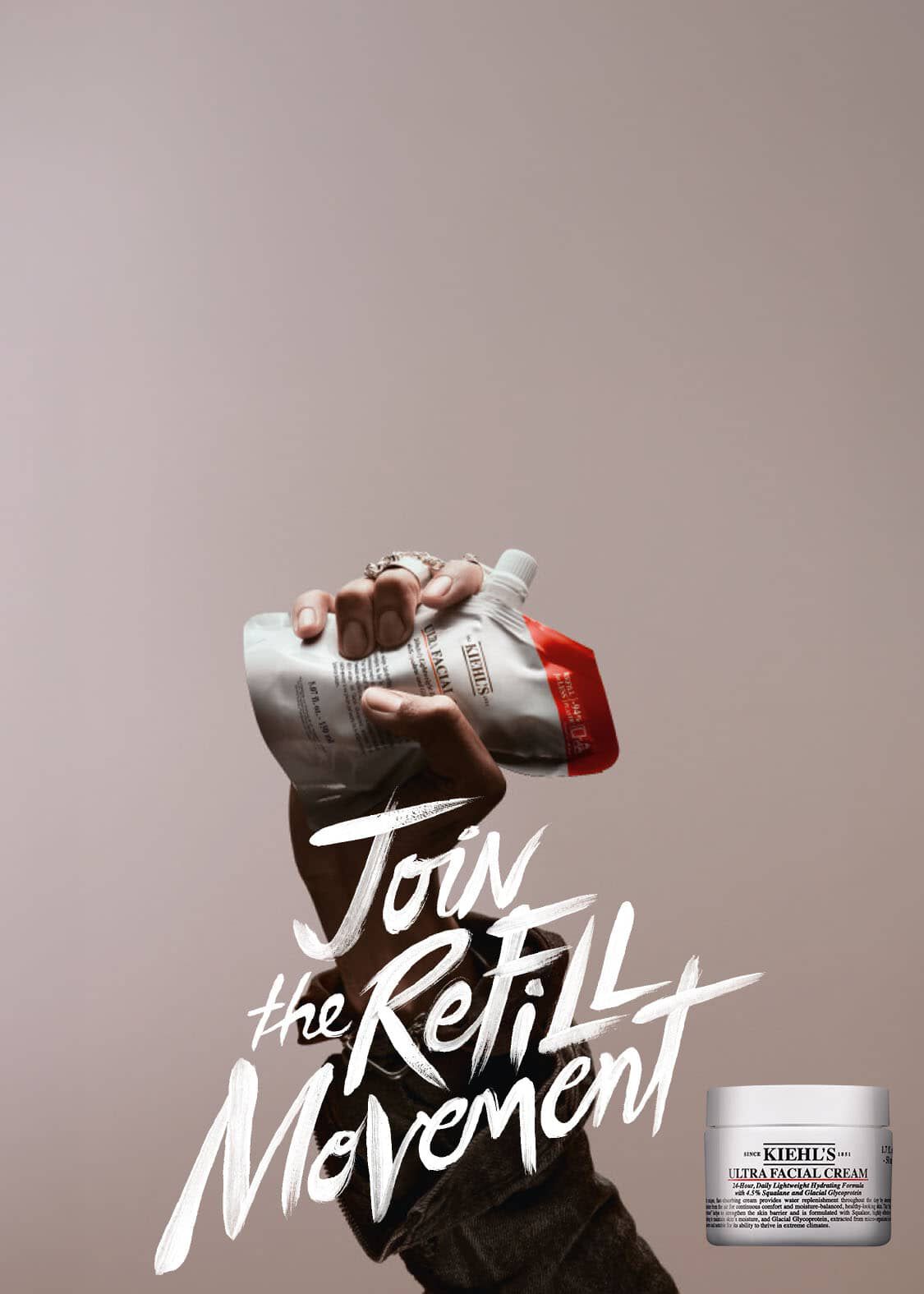 Reclamebanner met een opgeheven hand die een witte « Ultra Facial » navulverpakking van Kiehl's stevig vasthoudt tegen een minimalistische taupe achtergrond. Naast de handgeschreven witte tekst 'Join the Refill Movement' staat de paginatitel 'ONTDEK ONS ASSORTIMENT REFILLS' en de ondertitel 'Bespaar op je favoriete producten zonder je routine te veranderen. Vul je vertrouwde formules eenvoudig na voor hetzelfde resultaat, maar voor een veel slimmere prijs.', met daaronder een zwarte knop 'Ontdek nu'.