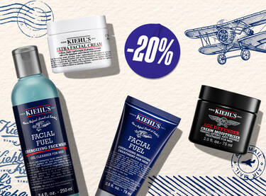Een promotiebanner van Kiehl's voor Vaderdag. De afbeelding toont vier bestsellers: Facial Fuel gezichtsreiniger, Facial Fuel scrub, Ultra Facial Cream en Age Defender oogcreme. Het ontwerp heeft een vintage thema met illustraties van een vliegtuig, luchtpoststempels en een "SHOP NOW" knop.