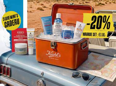 Kiehl's Oil-Free Essentials set in een vintage koelbox op een blauwe auto, omringd door ijs en een landkaart.