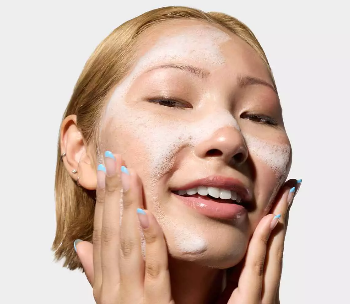 Flessen met Kiehl's formules met vitamine C en sinaasappels en sinaasappelschijfjes op de achtergrond