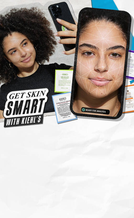 Een jonge vrouw met krullend haar houdt een smartphone vast en kijkt naar de camera. Op de smartphone staat een gezichtsanalyse-app open, omgeven door productlabels van Kiehl's. Tekst overlay: "GET SKIN SMART WITH KIEHL'S".