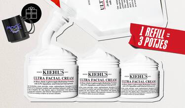 Promotionele afbeelding van Kiehl's Ultra Facial Cream. Bovenaan knijpt een witte navulverpakking (recharge) een stroom witte gezichtscreme uit die zich verdeelt over drie geopende potten van de Ultra Facial Cream. Aan de rechterkant staat een rode, schuine banner met de witte tekst "1 REFILL = 3 POTJES". Linksboven is een zwarte mok afgebeeld met het paarse logo "My Kiehl's Rewards", vergezeld van een rond zwart icoontje met de witte omtrek van een cadeautje.