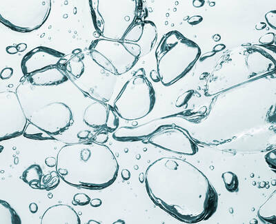 Close-up image of various clear water bubbles floating in a light background, creating a sense of movement and fluidity.