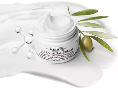Kiehl's Ultra Facial Cream jar with a creamy texture and olive branch, highlighting hydration and skincare benefits.