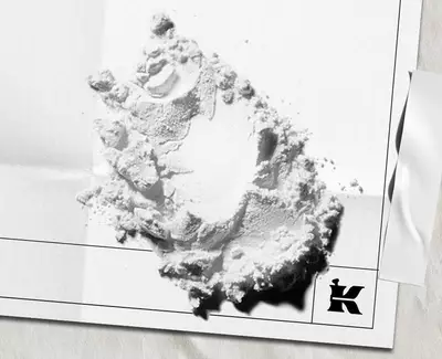 White powder ingredient scattered on white paper packaging with the Kiehl’s logo.