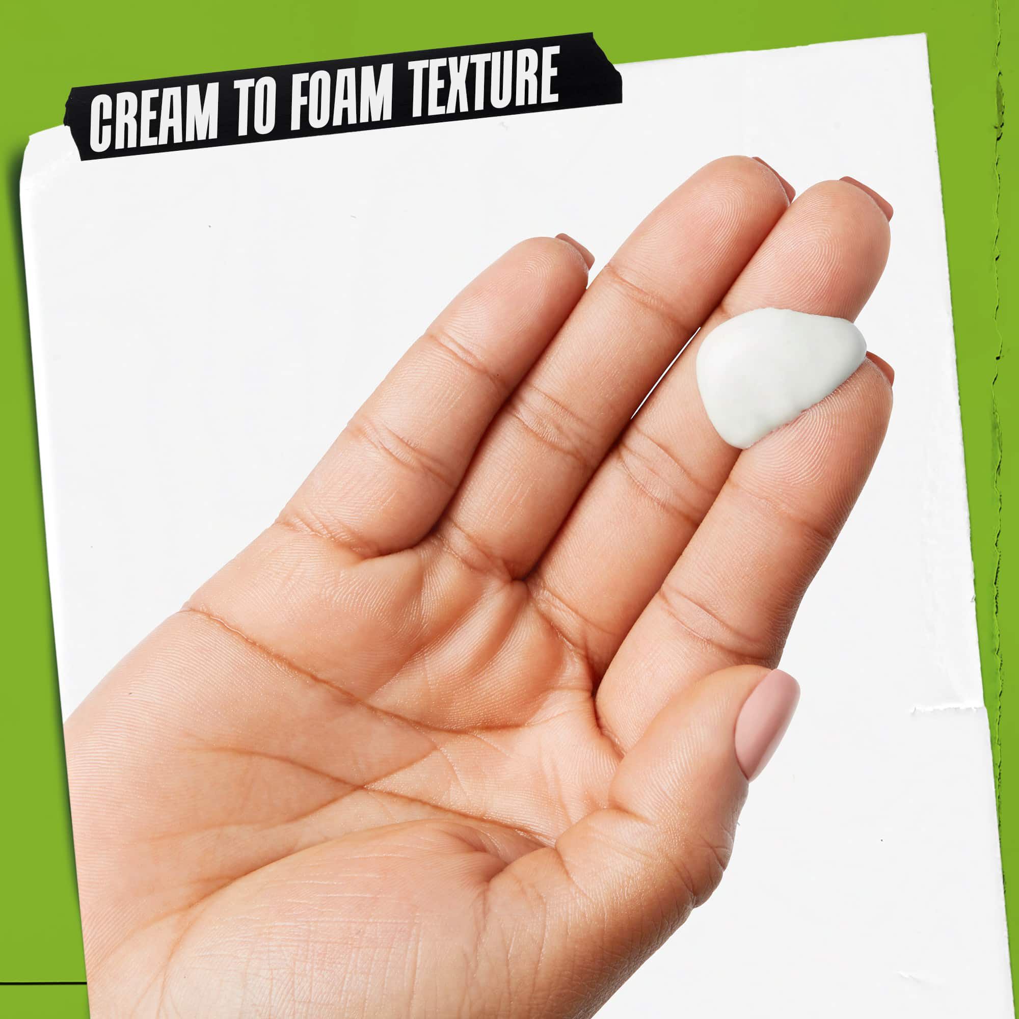 Een hand met Rare Earth Deep Pore Daily Cleanser erop. De tekst benadrukt: "Creme-naar-schuim textuur".