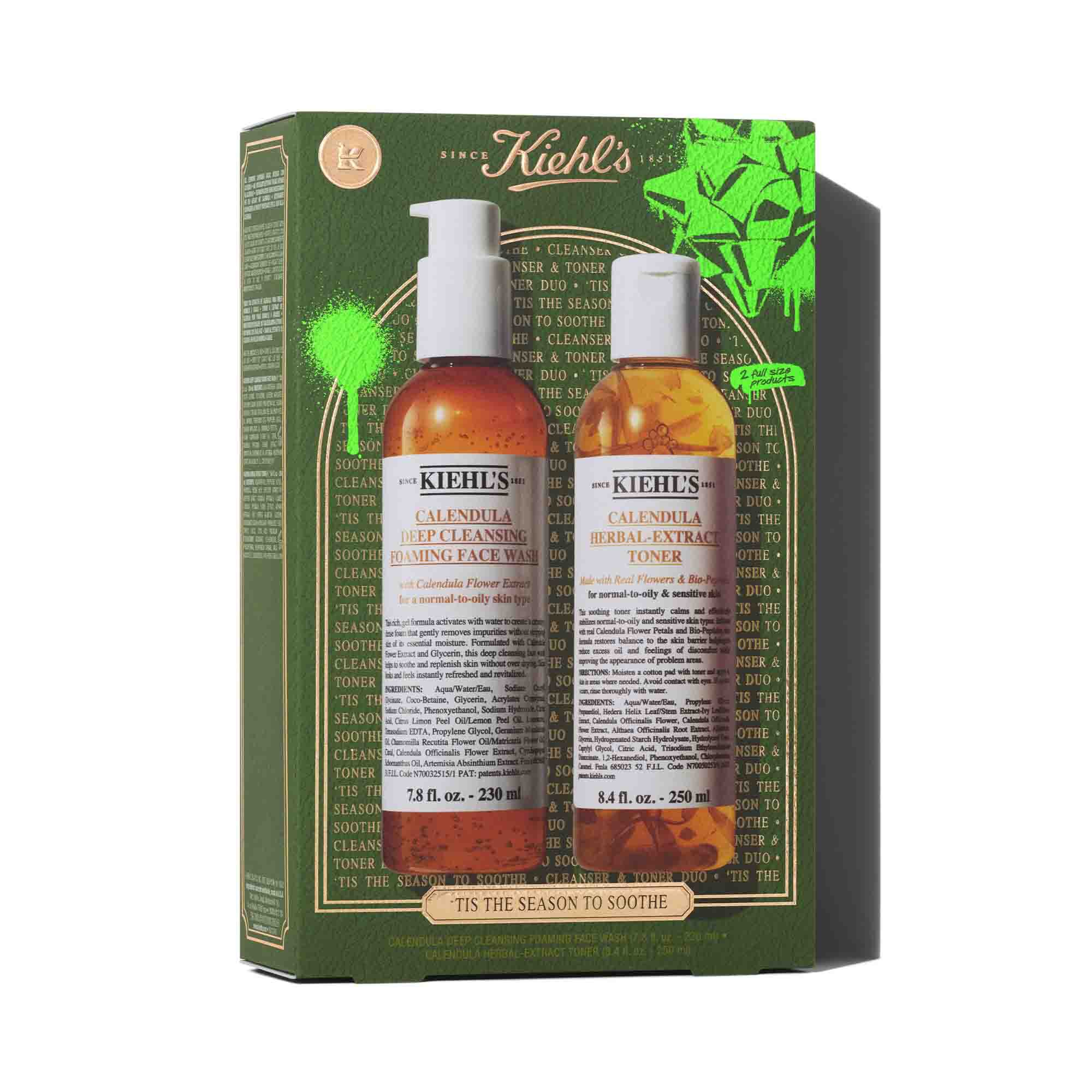 Een afbeelding van een groene en gouden geschenkdoos van Kiehl's met twee flessen: "KIEHL'S CALENDULA DEEP CLEANSING FOAMING FACE WASH" en "KIEHL'S CALENDULA HERBAL-EXTRACT TONER." De doos is versierd met felgroene accenten en de zin "TIS THE SEASON TO SOOTHE" onderaan.