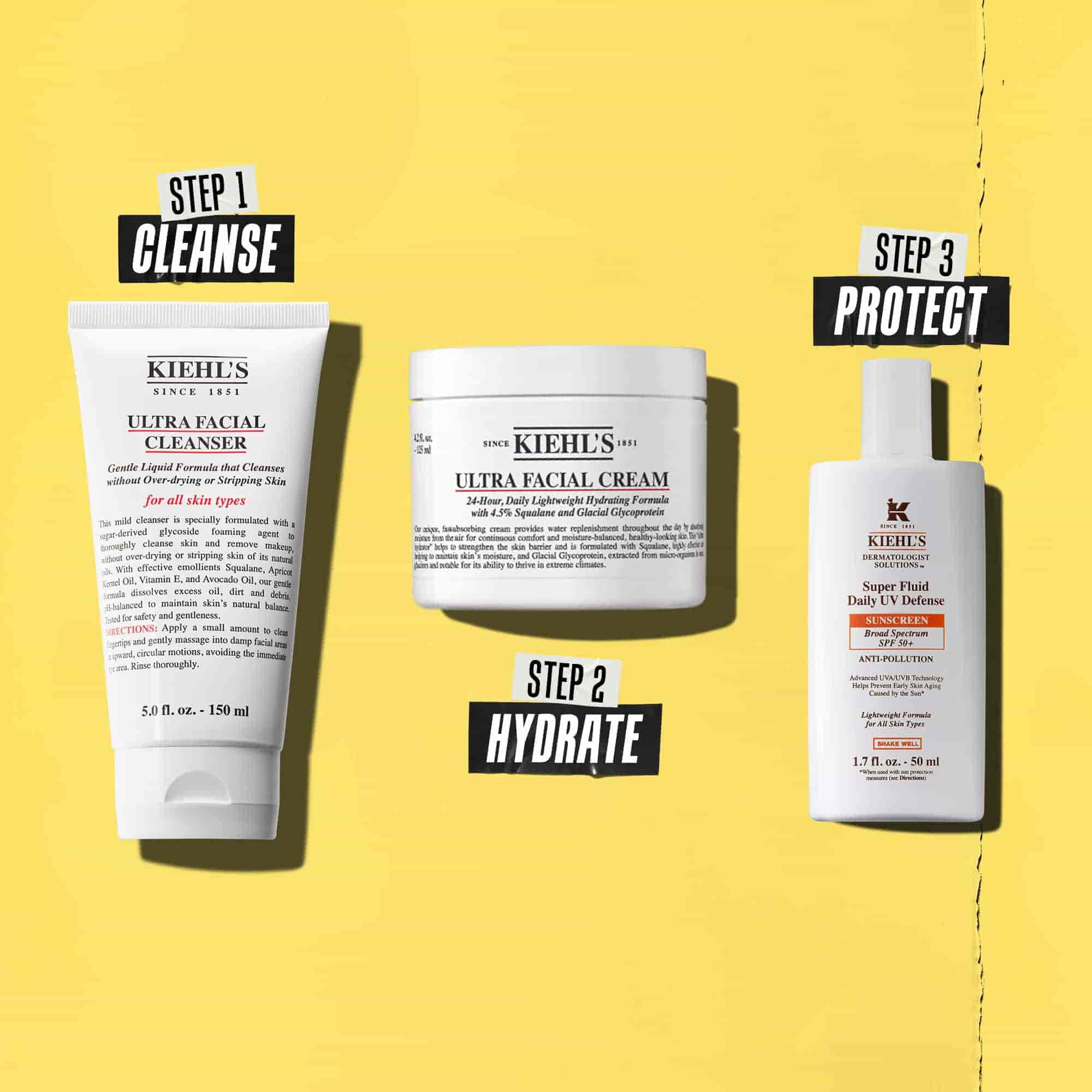 Drie Kiehl's producten die een routine vertegenwoordigen. Van links naar rechts: reiniger, vochtinbrengende creme en zonnebrandcreme.