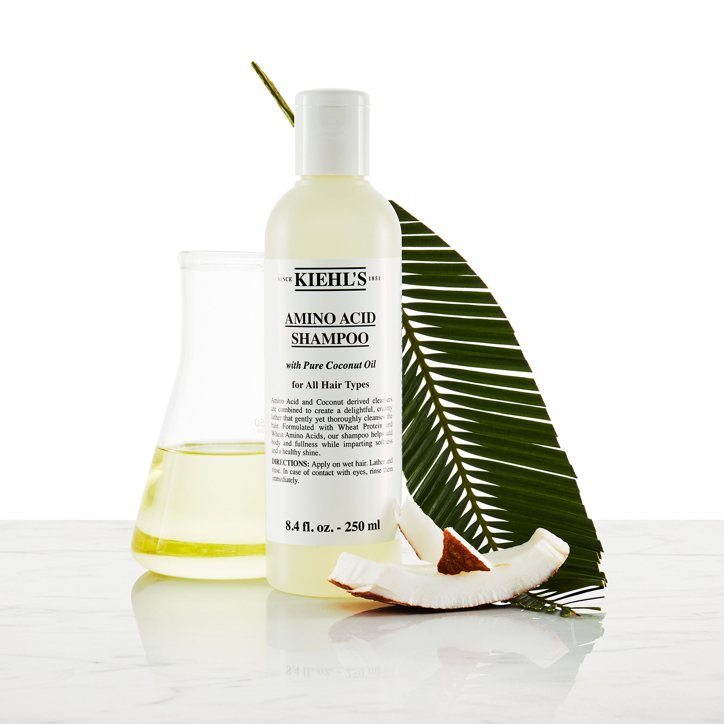 Model met snor en een fles Kiehl's Amino Acid Shampoo