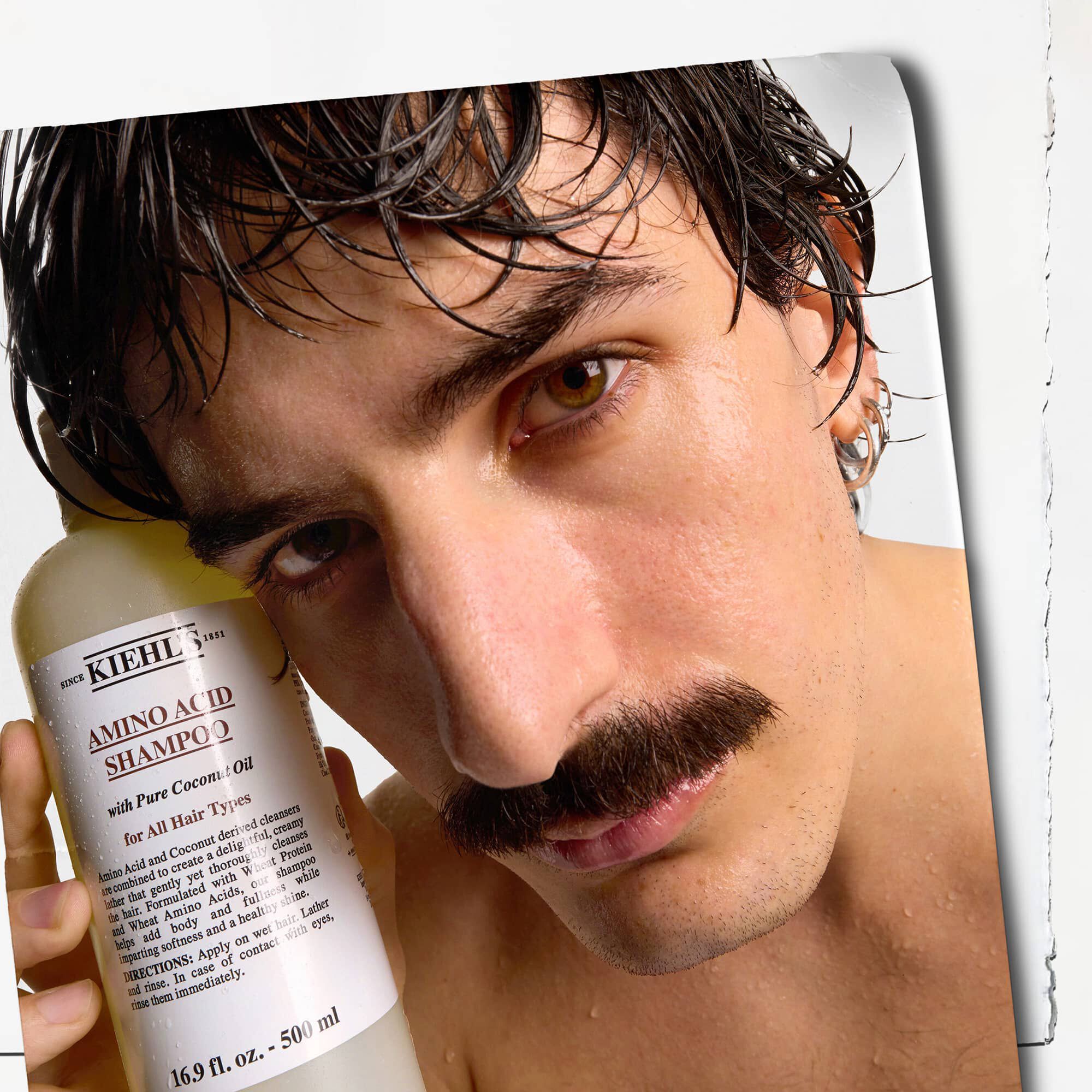 Model met snor en een fles Kiehl's Amino Acid Shampoo
