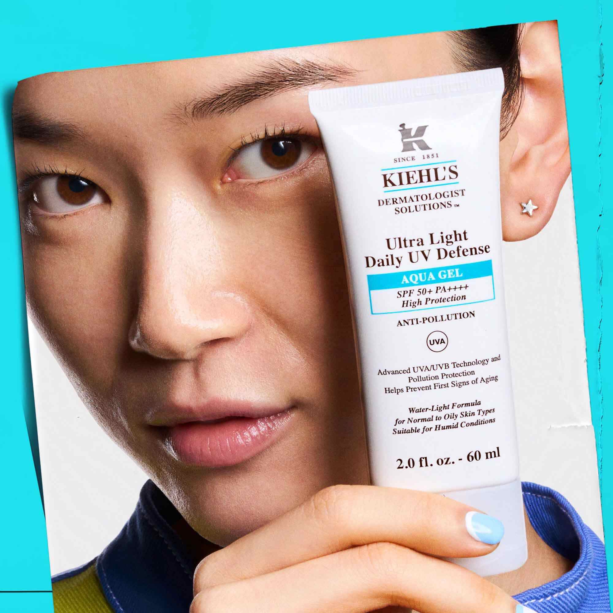 Een model dat een tube Ultra Light Daily UV Defense Aqua Gel vasthoudt, wat de draagbaarheid en het gebruiksgemak laat zien.