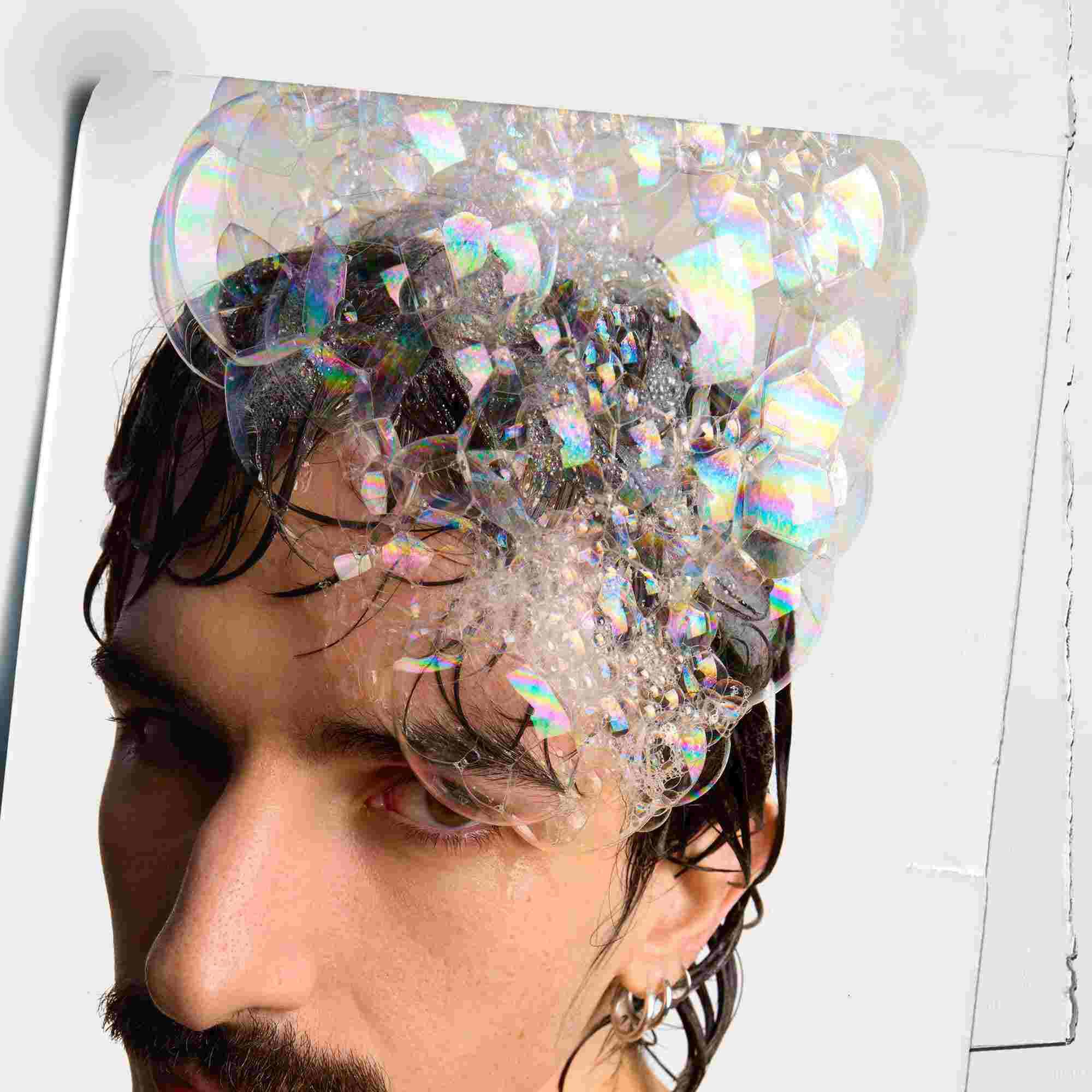 Model met bellen op het hoofd van Kiehl's Amino Acid Shampoo