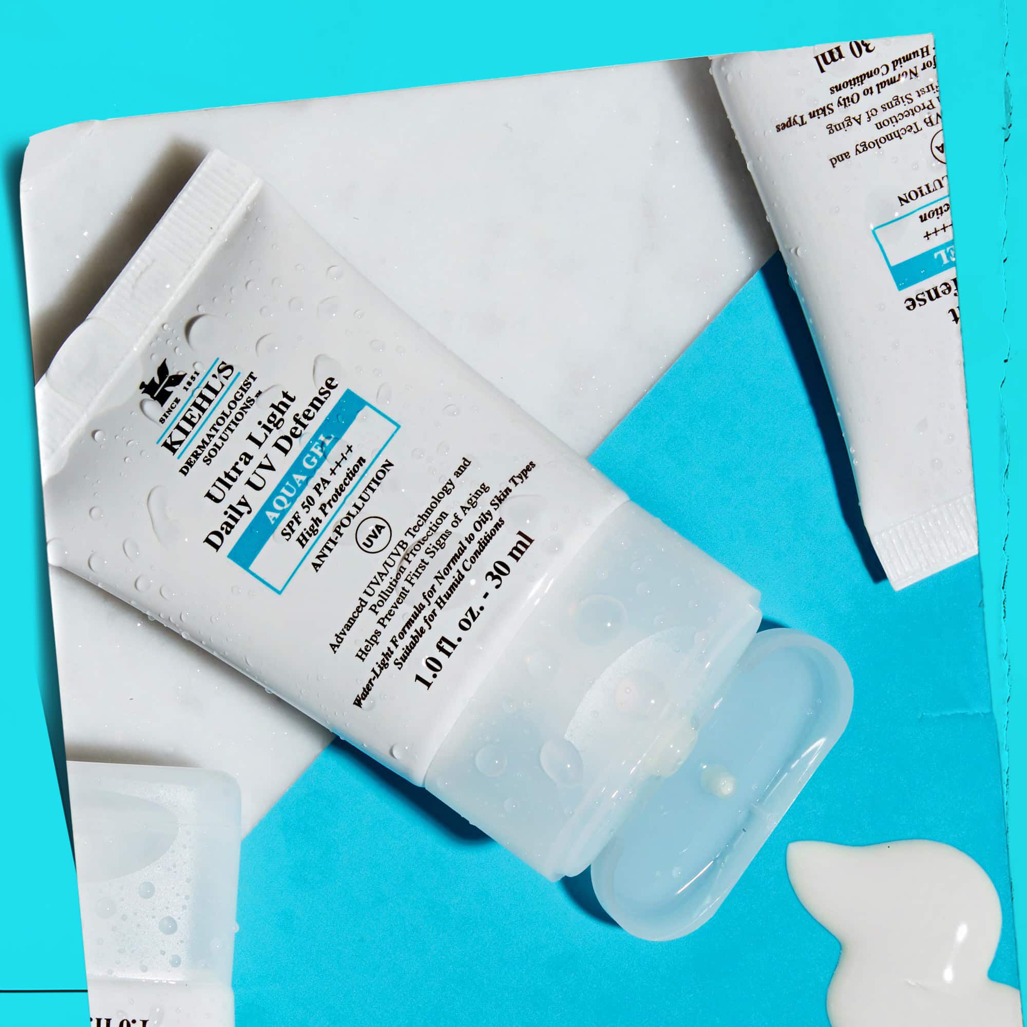 Een flat-lay van meerdere Ultra Light Daily UV Defense Aqua Gel tubes op een marmeren oppervlak, wat hun lifestyle-uitstraling laat zien.