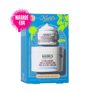 Een afbeelding van een blauwe geschenkdoos van Kiehl's. De doos bevat twee witte potten: "KIEHL'S ULTRA FACIAL CREAM" en "KIEHL'S ULTRA BODY MEGA MOISTURE SQUALANE CREAM." De doos heeft felgroene verfspetters en een strikontwerp en op de voorkant staat de tekst "HYDRATION ALL THE WAY".