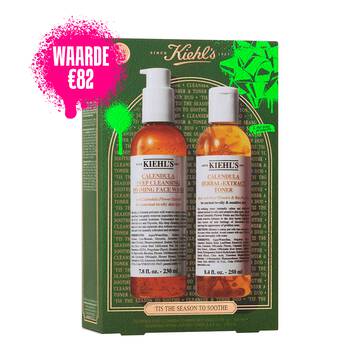 Een afbeelding van een groene en gouden Kiehl's geschenkdoos met vooraan twee flesjes: "KIEHL'S CALENDULA DEEP CLEANSING FOAMING FACE WASH" en "KIEHL'S CALENDULA HERBAL-EXTRACT TONER." De doos is versierd met felgroene accenten en de zin "TIS THE SEASON TO SOOTHE" onderaan.